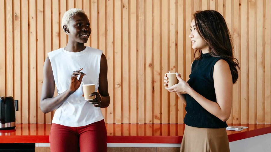 Zwei Frauen unterhalten sich bei einer Tasse Kaffee.