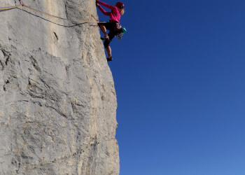 Evelyne Binsack beim Klettern, im Hintergrund Bergmassiv