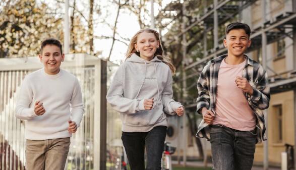 3 Jugendliche laufen die Straße entlang