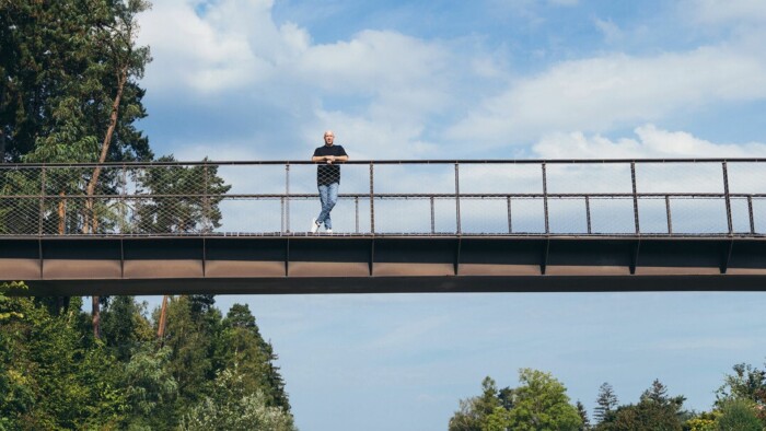 Sozialbetreuer auf einer Brücke mit Blick ins Grüne – Symbolbild für Unterstützung von Straffälligen beim Weg zurück in ein geregeltes Leben. Die ruhige Naturkulisse steht für neue Perspektiven, soziale Integration und professionelle Begleitung im Bereich der Straffälligenhilfe und Resozialisierung.