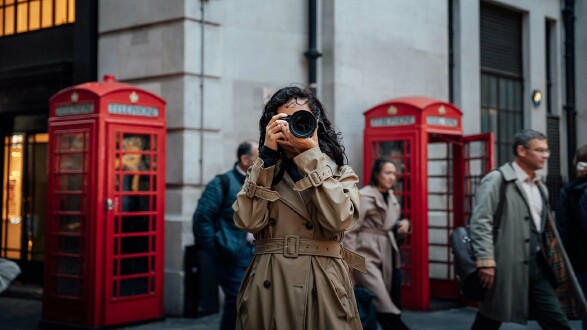 Touristin fotografiert in London vor roten Telefonzellen – Symbolbild für Großbritannien Urlaub 2025 und neue ETA-Einreisebestimmungen
