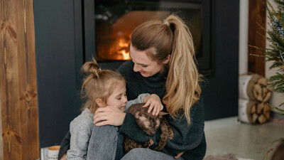 Warmes Zuhause in Vorarlberg: Familie vor dem Kamin – so gelingt sicheres und effizientes Heizen laut AK-Tipps