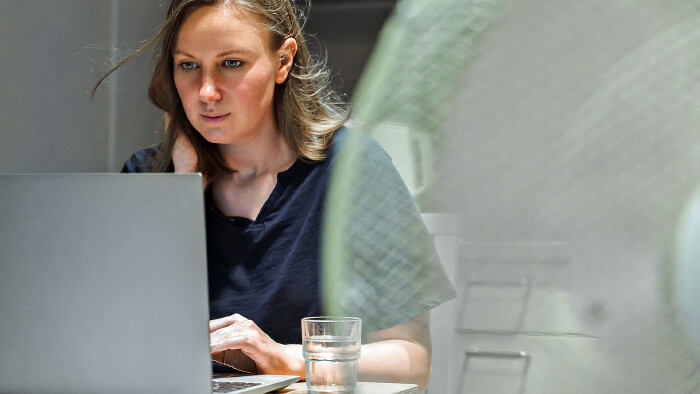 © M-Production, stock.adobe.com Junge Frau arbeitet im Büro bei Hitze
