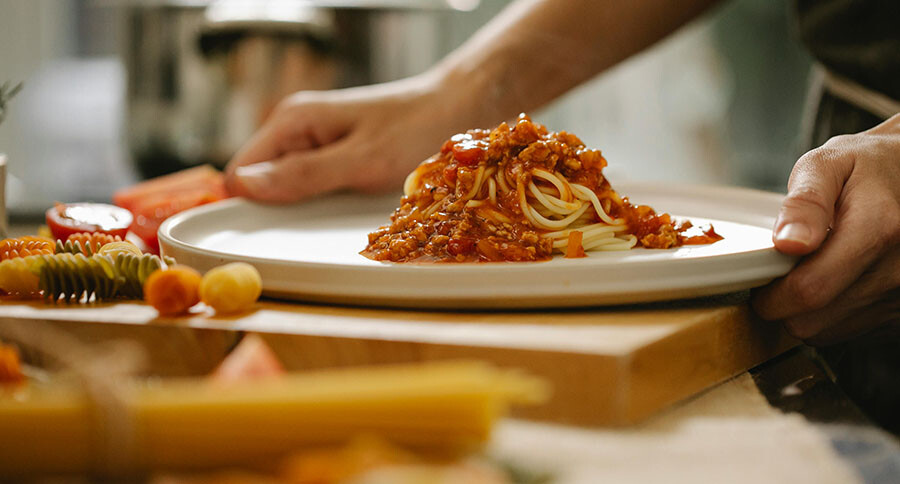 Eine Portion Spaghetti Bolognese liegt auf einem Teller.