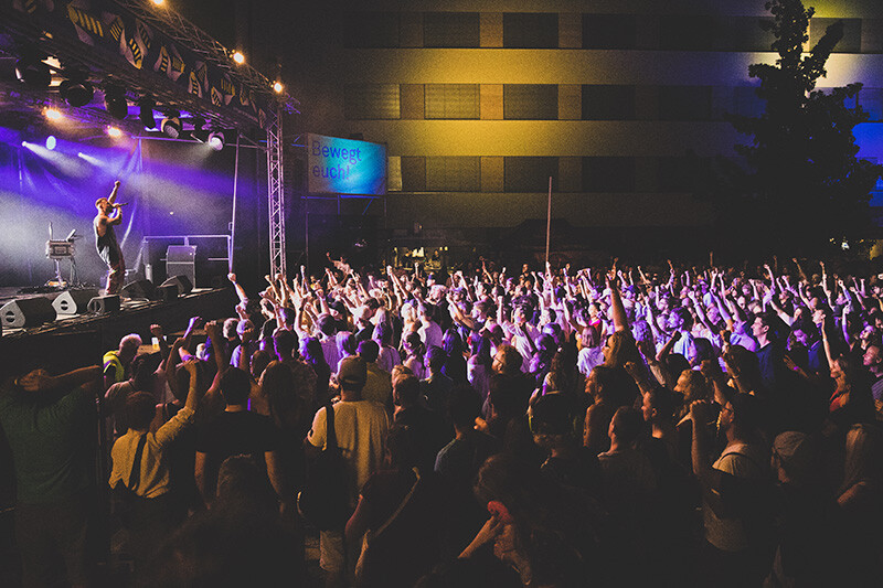 Das Foto zeigt einen Moment während des Schaffarei-Festivals: Auf der Bühne singt ein Musiker, vor der Bühne steht eine rieisige Menschenmenge, die mittanzt.
