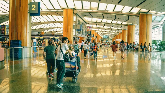 Wer so entspannt Richtung Gate rollt, hat wohl beim Buchen alles richtig gemacht. Wie du Flugfallen umgehst? Zeigen wir dir im Blog. © Adrian Agawin, Pexels Menschen am Flughafen mit Gepäck – sicher Flüge buchen und Flug-Abzocke vermeiden