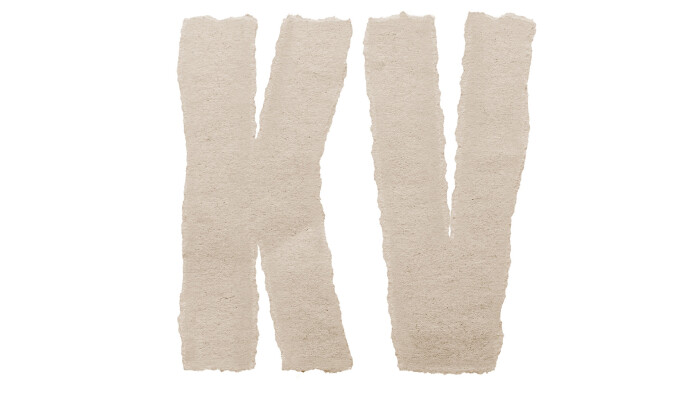 Die Buchstaben &bdquo;KV&ldquo; auf wei&szlig;em Hintergrund, gebildet aus ausgerissenen, hellbraunen Papierstreifen.