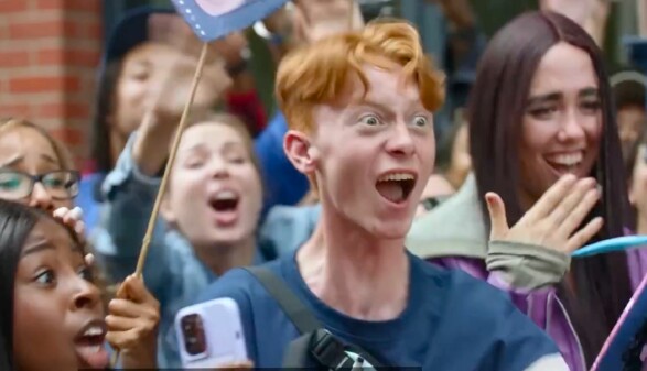 Screenshot aus dem Amazon-Werbespot: Ein Mann mit überzeichneter Mimik und glattem Gesichtsausdruck feiert sich selbst, umgeben von weiteren jubelnden Personen