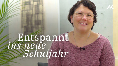 L&auml;chelnde Frau mit Brille vor einem B&uuml;ro Hintergrund