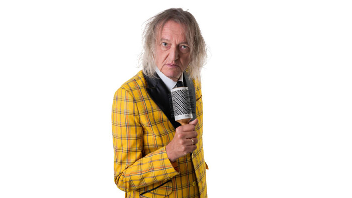 Markus Lindner im Portrait mit Haarb&uuml;rste als Mikrofon in der Hand