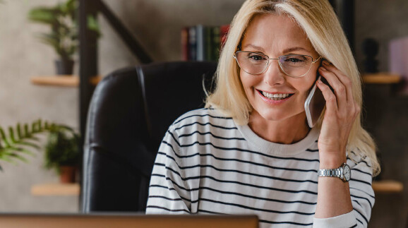 Frau am Schreibtisch mit Telefon