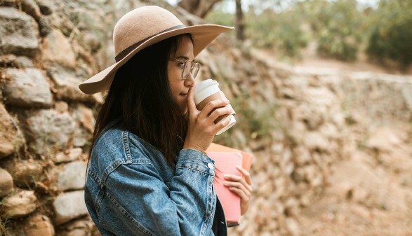 Arbeitnehmerin genießt Pause mit Kaffee – gesetzliche Pausenregelung im Arbeitsrecht erklärt
