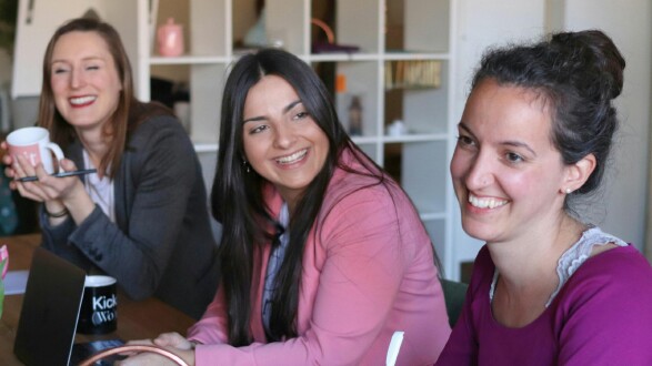 Drei Frauen sitzen an einem Tisch mit Laptops