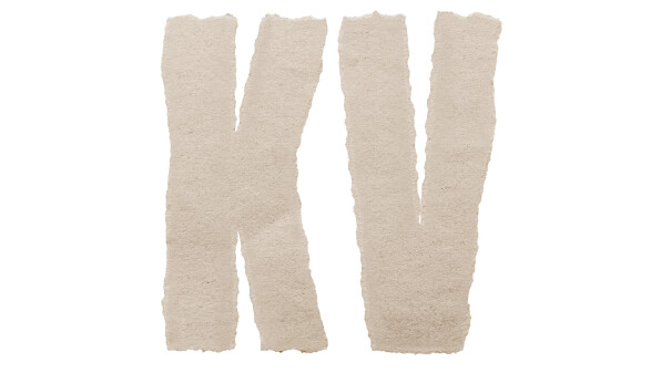 Die Buchstaben &bdquo;KV&ldquo; auf wei&szlig;em Hintergrund, gebildet aus ausgerissenen, hellbraunen Papierstreifen.