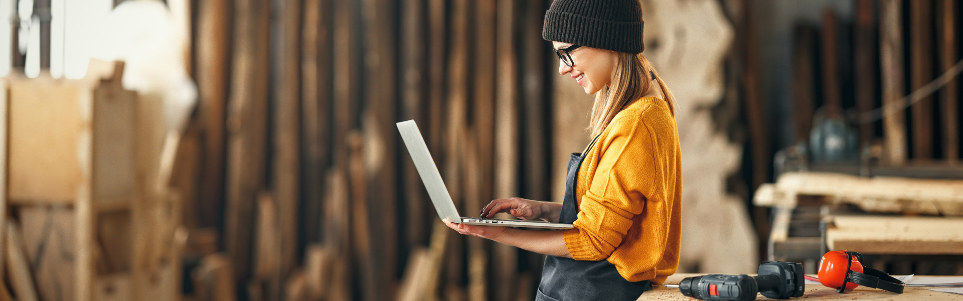 Frau mit Laptop in Montagehalle © Adobe Stock, JenkoAtaman