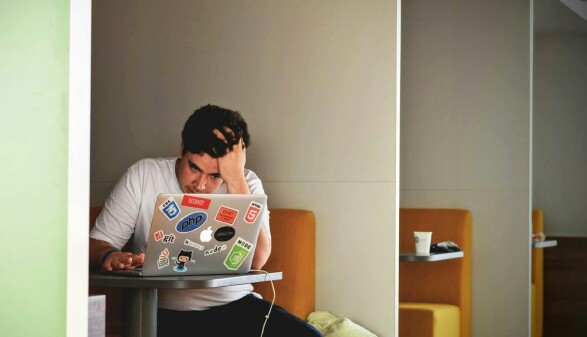 Ein Mann in einem Coffeeshop, der an einem Laptop sitzt