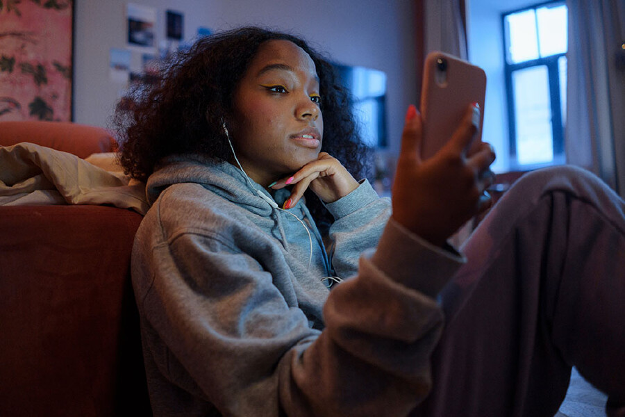 Ein junges Mädchen schaut auf ein Smartphone.