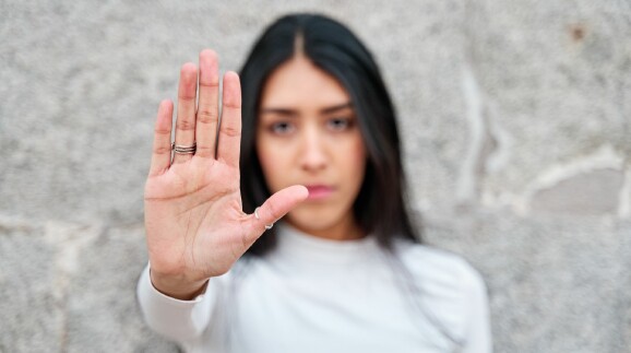 Eine Frau hebt ihre Hand, um Stopp zu signalisieren