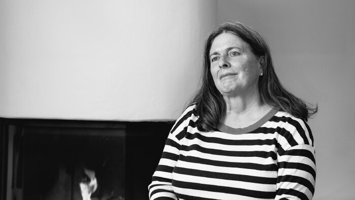 Ruth Laner erzählt im Museum des Wandels von ihrem Beruf als Bankangstellte – und wie der sich im Laufe der Jahrzehnte wandelte. © Hanno Mackowitz Ruth Laner sitzt auf einem Stuhl vor einem Kamin.