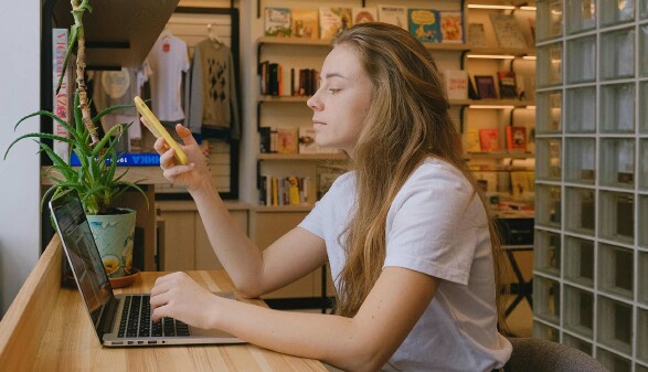 Junge Frau recherchiert am Laptop zur Herkunft des Black Friday