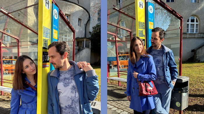 Zwei Menschen stehen an einer Bushaltestelle