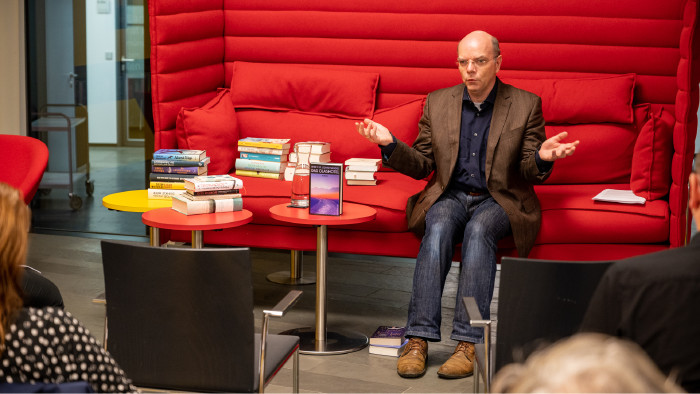 Alexander Kluy auf rotem Sofa mit Büchern  © AK / Marc Wolf