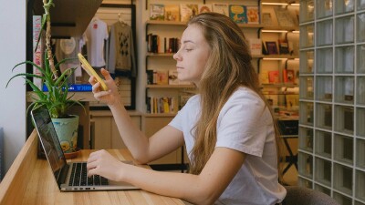 Junge Frau recherchiert am Laptop zur Herkunft des Black Friday