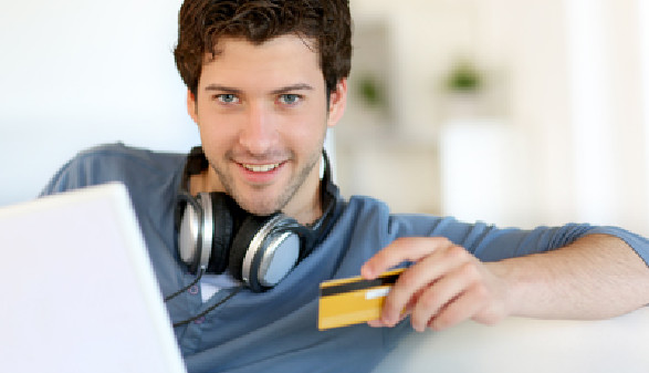 Mann sitzt vor einem Laptop und hält eine Kreditkarte in der Hand © goodluz, fotolia.com
