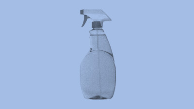 Transparente Sprühflasche mit ergonomischem Griff vor hellblauem Hintergrund – typisches Reinigungsprodukt im Test für effektive Badreiniger