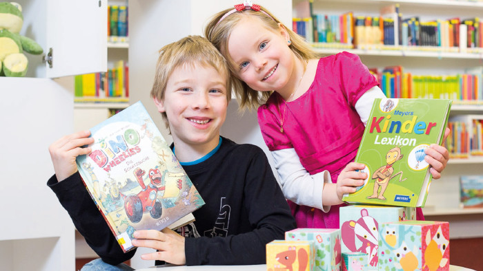 Lust an Sprache und Neugierde wecken © Dietmar Walser zwei Kinder mit Bilderbüchern in der Bibliothek © Dietmar Walser