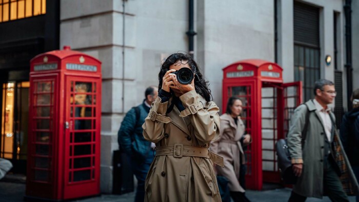 Touristin fotografiert in London vor roten Telefonzellen – Symbolbild für Großbritannien Urlaub 2025 und neue ETA-Einreisebestimmungen