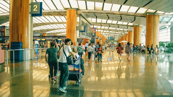 Menschen am Flughafen mit Gepäck – sicher Flüge buchen und Flug-Abzocke vermeiden