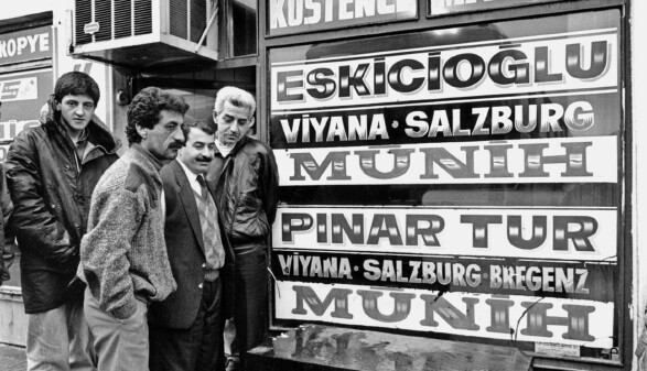 Menschen am Busterminal in Istanbul, auf den Schildern die Destinationen 