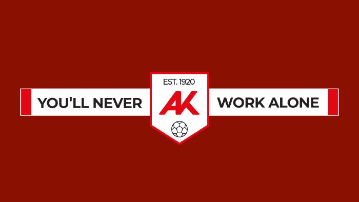 Grafik auf dunkelrotem Hintergrund: Ein wei&szlig;er Fanschal mit der Aufschrift &sbquo;YOU&rsquo;LL NEVER WORK ALONE&lsquo;. In der Mitte wird der Schal von einem wei&szlig;en Wappen unterbrochen, das das rote AK-Logo, das Gr&uuml;ndungsjahr &sbquo;EST. 1920&lsquo; und ein Fu&szlig;ball-Icon zeigt.