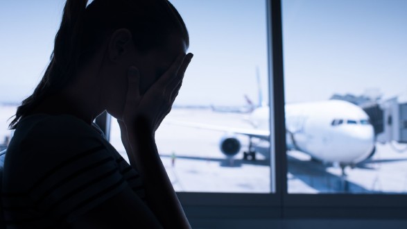 Verzweifelte Frau am Flughafen © Canva