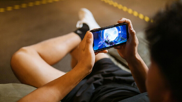 Ein Jugendlicher spielt ein Online-Game auf seinem Smartphone.