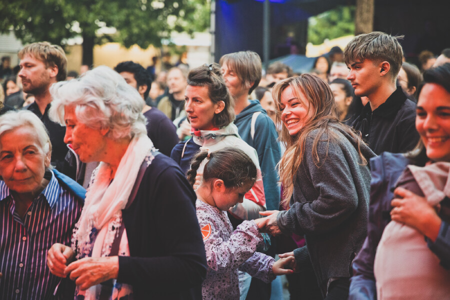 Menschen unterschiedlichen Alters, darunter Senioren, junge Erwachsene und Kinder, feiern gemeinsam in der dicht gedr&auml;ngten Menge auf dem Schaffarei Festival.