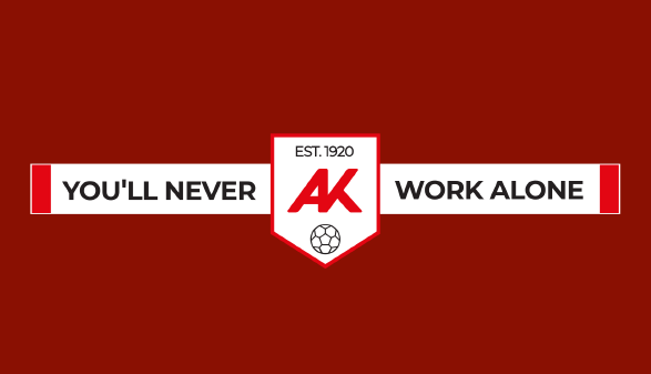 Grafik auf dunkelrotem Hintergrund: Ein wei&szlig;er Fanschal mit der Aufschrift &sbquo;YOU&rsquo;LL NEVER WORK ALONE&lsquo;. In der Mitte wird der Schal von einem wei&szlig;en Wappen unterbrochen, das das rote AK-Logo, das Gr&uuml;ndungsjahr &sbquo;EST. 1920&lsquo; und ein Fu&szlig;ball-Icon zeigt.
