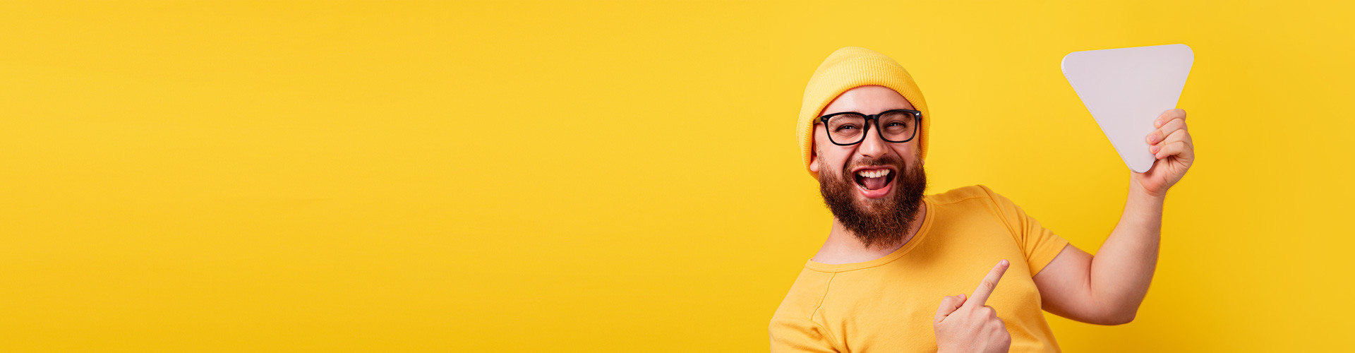 Fröhlicher lächelnder Mann, der in der Hand die Video-Play-Taste über gelbem Hintergrund hält © alesmunt, Adobe Stock