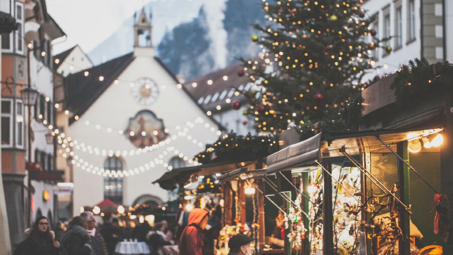 Ein lebhafter Feldkircher Weihnachtsmarkt in der Stadt mit Menschen, die die festliche Atmosphäre genießen.