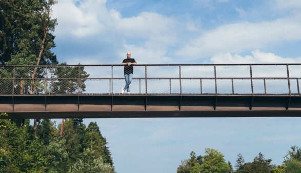 Sozialbetreuer auf einer Brücke mit Blick ins Grüne – Symbolbild für Unterstützung von Straffälligen beim Weg zurück in ein geregeltes Leben. Die ruhige Naturkulisse steht für neue Perspektiven, soziale Integration und professionelle Begleitung im Bereich der Straffälligenhilfe und Resozialisierung.