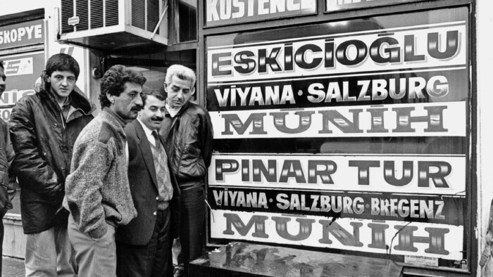 Menschen am Busterminal in Istanbul, auf den Schildern die Destinationen 